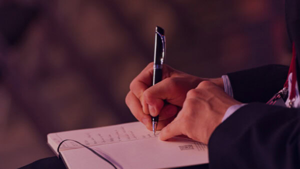 A Nordic Business Forum Attendee making notes at the event